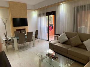 a living room with a couch and a table at Beautiful cozy apartment with pool in Marrakesh