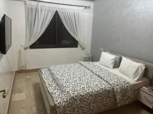 a bedroom with a large bed with a window at Beautiful cozy apartment with pool in Marrakesh