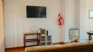 un soggiorno con un divano e una TV a parete di La Chile a Salta