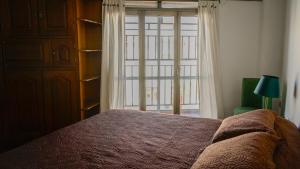 una camera da letto con un letto e una grande finestra di La Chile a Salta Altre 28 foto