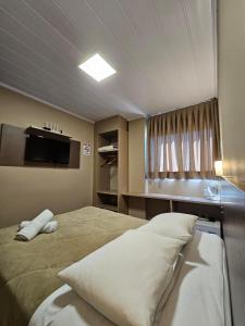Un dormitorio con una cama grande con ventana. en Pousada Villa Serrana, en Bom Jardim da Serra