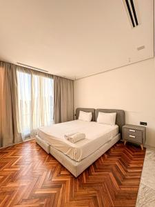 Un dormitorio con una cama grande y suelo de madera. en Penthouse de Prestige, en Tánger