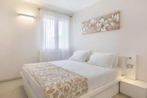 une chambre blanche avec un grand lit avec une fenêtre dans l'établissement Locanda Corte Montioni, à Lazise 30 autres photos