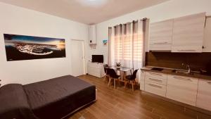 a bedroom with a bed and a kitchen with a table at La Perla del sur in Bari
