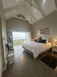 a bedroom with a large bed and a large window at Beach House Princes Grant Golf Estate in Blythedale