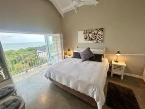 a bedroom with a bed with a view of the ocean at Beach House Princes Grant Golf Estate in Blythedale +76 photos