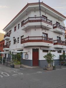 a large white building with balconies on top of it at La Perla, vivienda vacacional in Garachico +40 photos