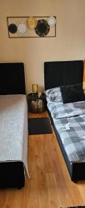 a bedroom with two beds and a wooden floor at Ubytovanie Sosna Muráň in Muráň +3 photos