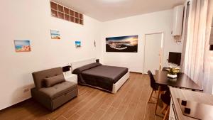 a bedroom with a bed and a chair and a desk at La Perla del sur in Bari