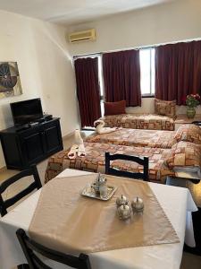 a room with two beds and a table and chairs at Studiotel Afoud in Agadir