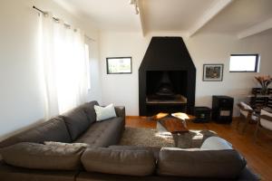 a living room with a couch and a fireplace at Bo-den-See Cottage in Groot Brak Rivier +10 photos