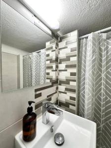 a bathroom with a sink with a soap dispenser on it at Appartement cosy jardin et clim in Sète