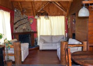 a living room with white furniture and a fireplace at Casa Los Coihues in Villa La Angostura