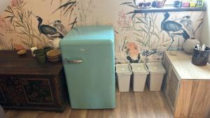 a blue refrigerator in a room with trash cans at Charming studio by the river in Uście Gorlickie