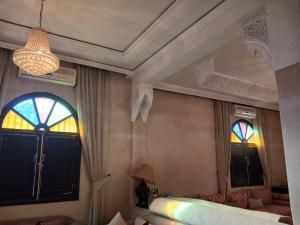 a bedroom with a bed and a mirror and a window at Villa Lmima Malika in Marrakesh