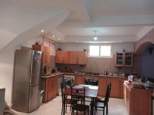 a kitchen with a refrigerator and a table with chairs at Villa Lmima Malika in Marrakesh
