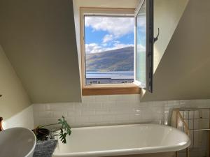 a bathroom with a bath tub and a window at Highland Rooms - Room Only No Breakfast in Ullapool