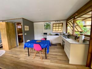 a kitchen with a blue table and pink chairs at Fare Matatia in Punaauia