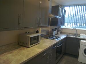 a kitchen with a microwave oven and a sink at The Dorchester Serviced Apartments in Hull
