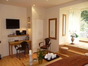 sala de estar con mesa, sillas y TV en Annesdale House en Windermere