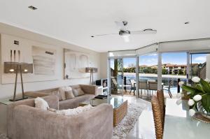 a living room with a couch and chairs and a table at Skippers Cove Waterfront Resort in Noosaville