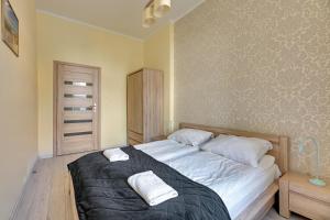 a bedroom with a bed with two towels on it at Bryza - apartament w Sopocie by Grand Apartments in Sopot
