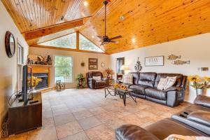 ユーレカ・スプリングスにあるWaterfront Beaver Lake House with Deck and Fire Pit!のリビングルーム(革製家具、木製の天井付)