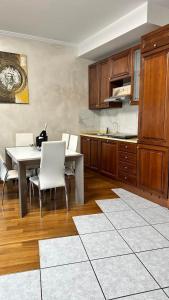 cocina con mesa, sillas blancas y encimera en Lavilletta stanza parco, en Baranzate