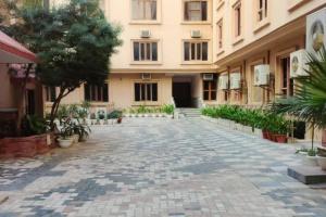 范兰德凡Divine AC studio in Ananda Krishna Van 2 mins from ISKCON的一座树木和植物的建筑的空旷庭院