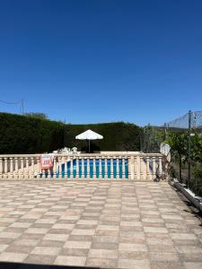 a pool with an umbrella and a table and a chair at Casa en la huerta - Villa Encarna in Caravaca de la Cruz