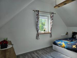 a bedroom with a bed and a window at Spokojny zakątek in Ustroń