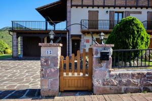 a house with a wooden gate and a fence at Goizeder etxea in Sumbilla