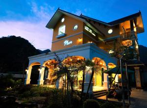 a building with a clock on the side of it at Plum Village Moc Chau in Mộc Châu
