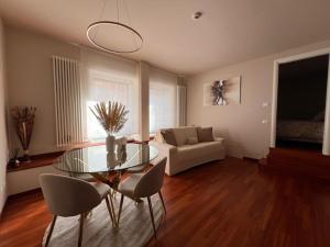 a living room with a glass table and chairs at Loft 46 in Campobasso