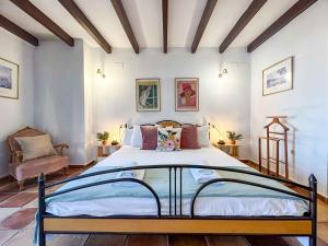 Un dormitorio con una cama grande y una silla. en Casa Moll. Tradición y bonitas vistas de Alicante, en Alicante