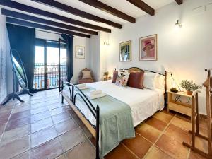 Un dormitorio con una cama y una ventana grande. en Casa Moll. Tradición y bonitas vistas de Alicante, en Alicante