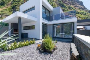 una casa blanca con una montaña al fondo en CasaMar, en Jardim do Mar