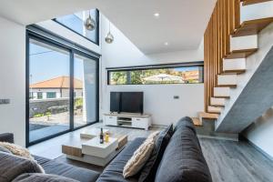Una sala de estar con un sofá y un televisor. en CasaMar, en Jardim do Mar