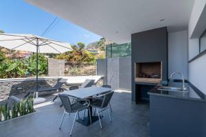 Una cocina y un comedor con mesa y sillas. en CasaMar, en Jardim do Mar