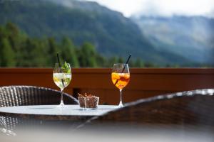 two glasses of wine sitting on a table at Hotel Chesa Spuondas in St. Moritz +92 photos