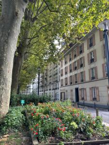 un parque con flores frente a un edificio en Appt 4pers à 150m du métro École vétérinaire - aux portes de Paris et Disney !, en Maisons-Alfort