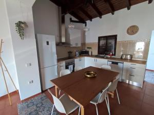 a kitchen with a wooden table and white appliances at Casa da Pedra in Pedrógão