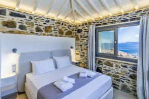 una camera da letto con un letto e una grande finestra di Jonina Resort a Skopelos Town Altre 112 foto