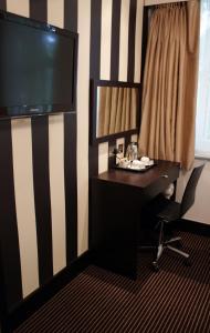 a room with a desk and a television at Hotel Edward Paddington in London