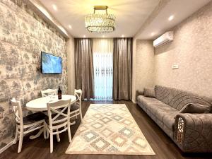 ein Wohnzimmer mit Sofa und Tisch in der Unterkunft White city apartment in Baku