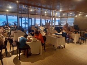a group of people sitting at tables in a restaurant at Paradise Hotel Akcay in Edremit