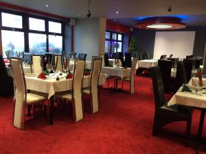 un comedor con mesas y sillas blancas en Sunny Days Hotel, en Blackpool