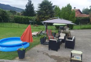 La Campachalet en san justo的一组椅子、一把遮阳伞和一个游泳池