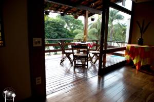 a room with a table and chairs on a deck at Da Orla Pampulha Hostel in Belo Horizonte