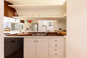 una cucina con mobili bianchi e un lavandino di Navona Historic Luxury Deluxe a Roma